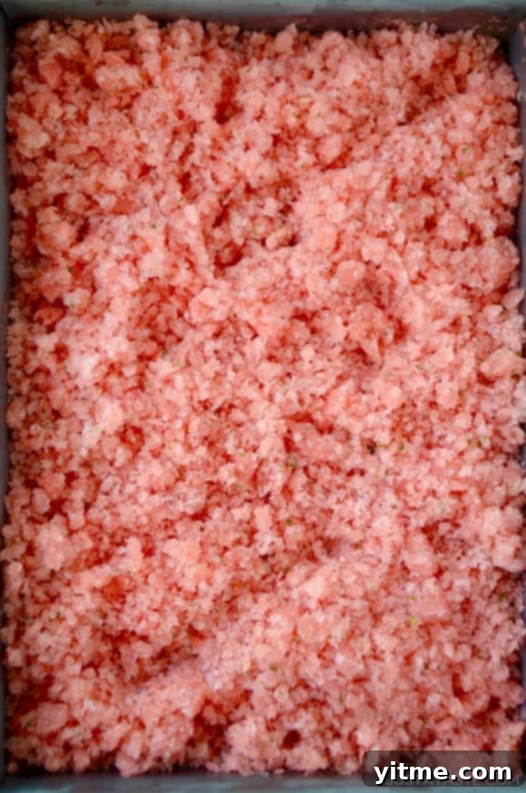 Top down view of metal baking sheet containing watermelon granita
