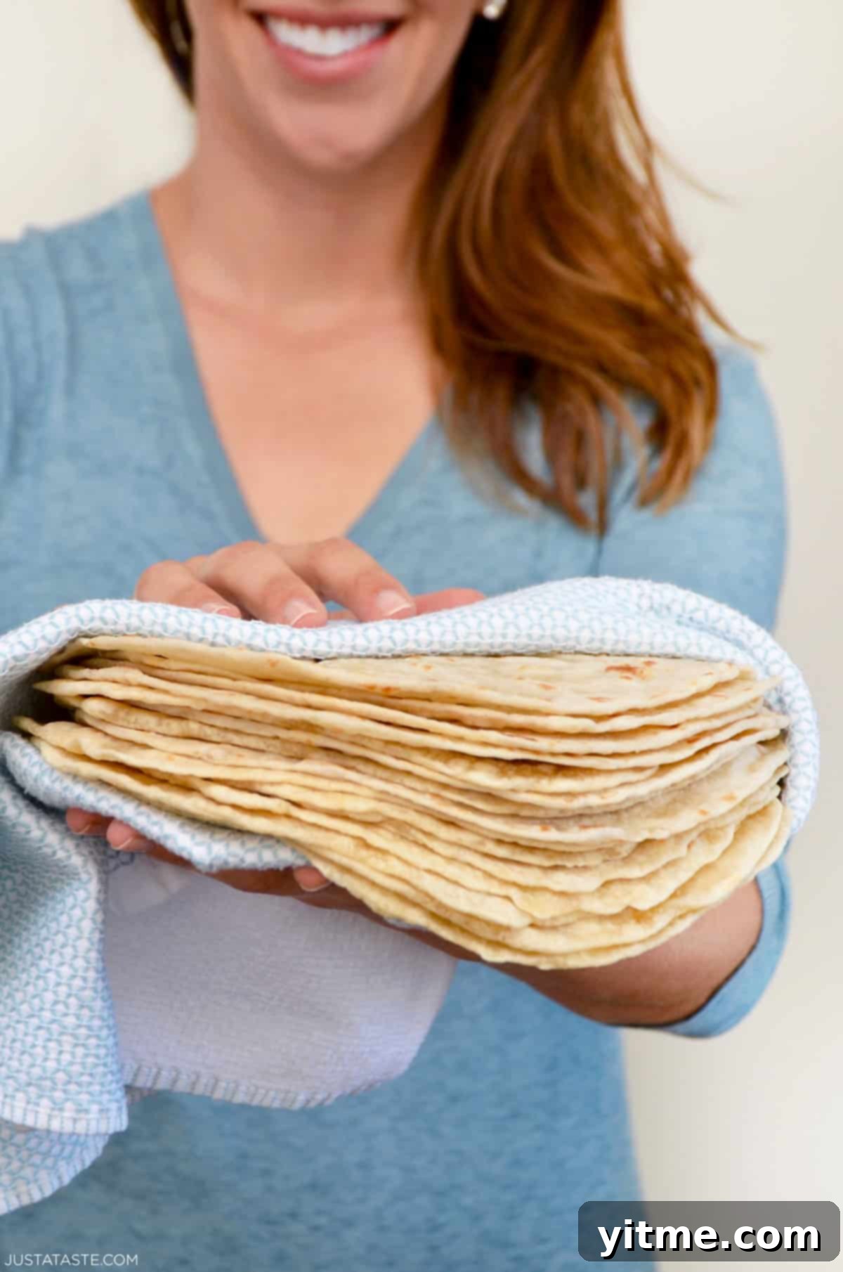 Person holding a stack of homemade tortillas.