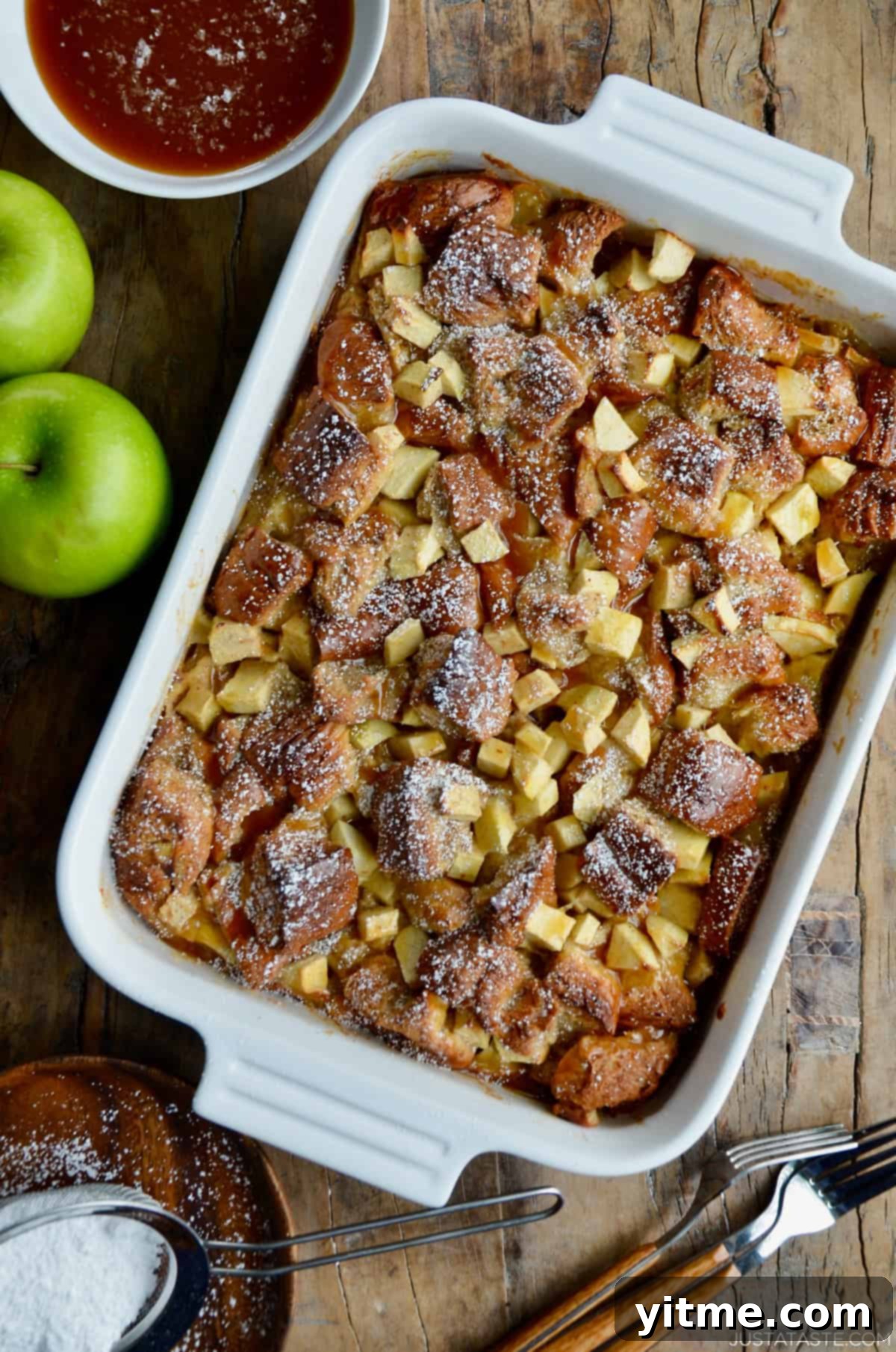 Apple bread pudding with chopped green apples visible, in a white 9x13 baking dish.