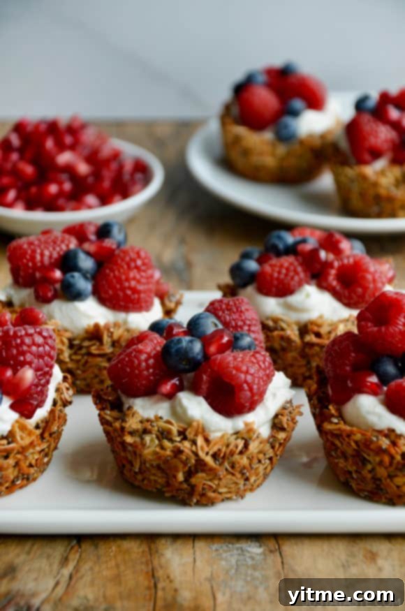 Cups of granola topped with yogurt and fresh fruit