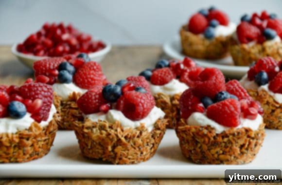 Easy Muffin Tin Granola Cups topped with yogurt and fresh berries on white serving plate