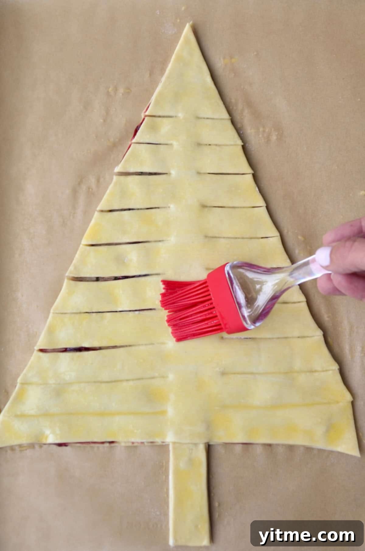 Brushing egg wash atop holiday puff pastry appetizer.