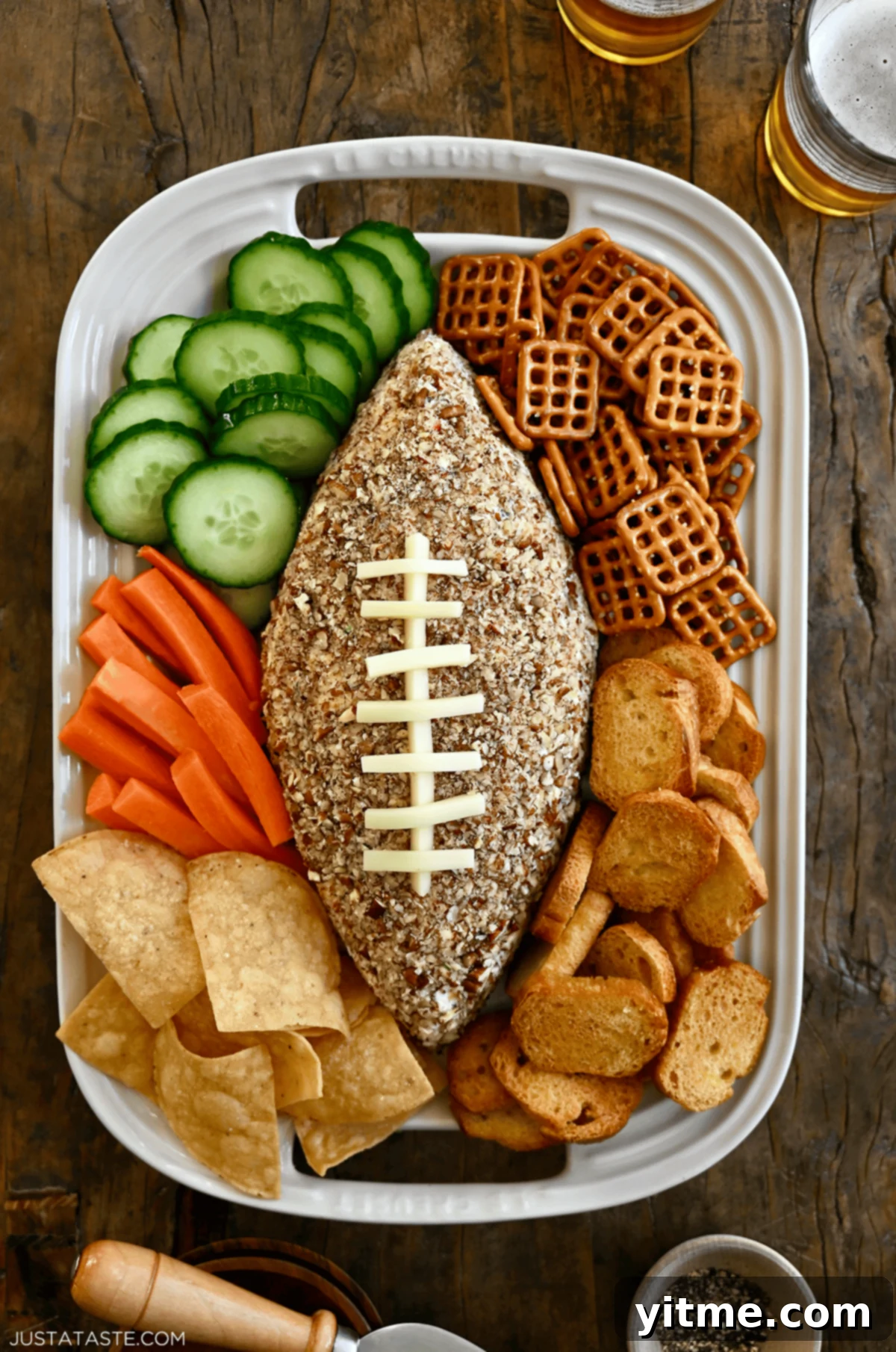 A delicious football-shaped cheese ball surrounded by dippers.