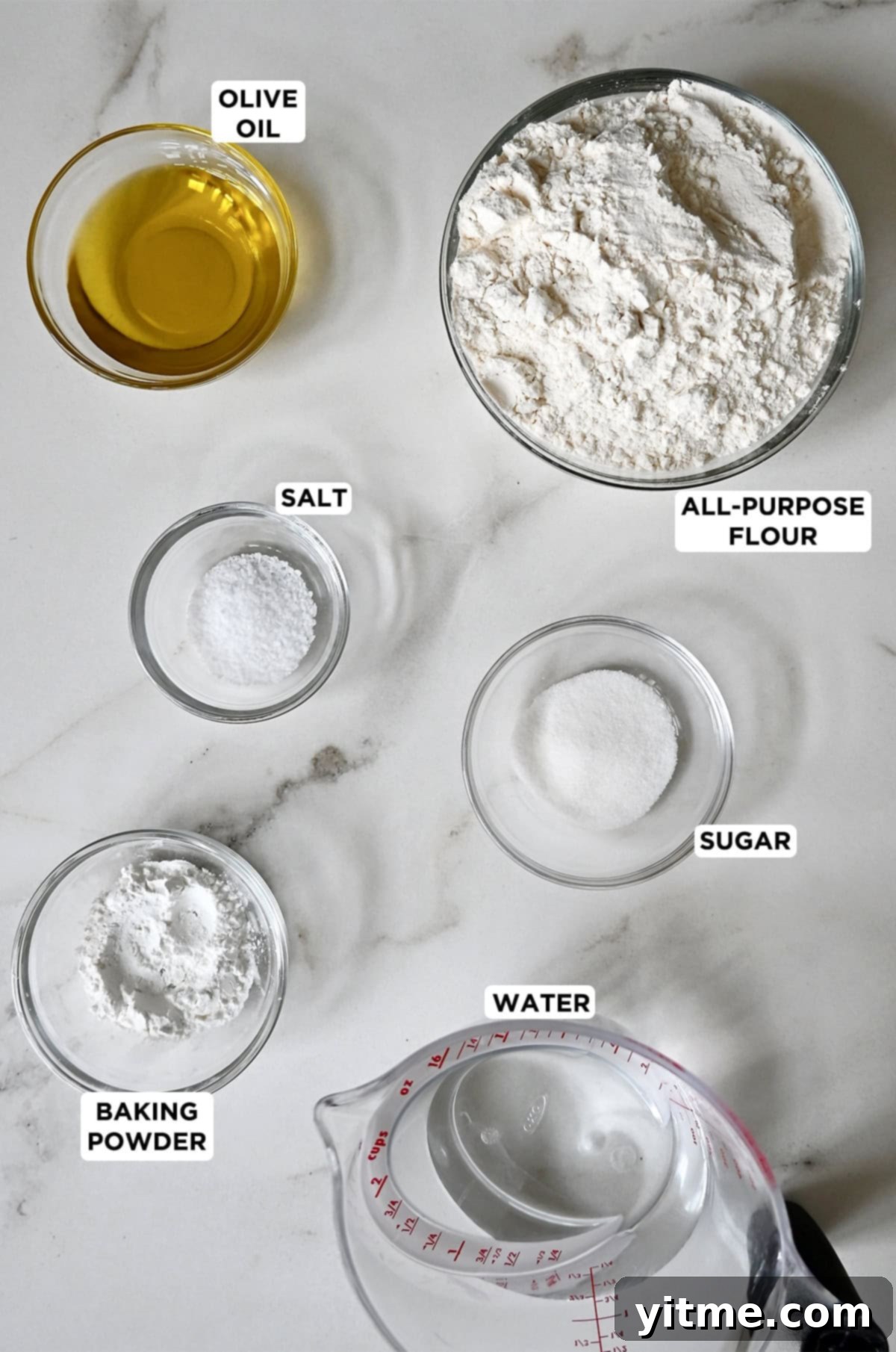 No yeast pizza crust ingredients neatly arranged in glass bowls, including olive oil, all-purpose flour, granulated sugar, kosher salt, water, and baking powder.