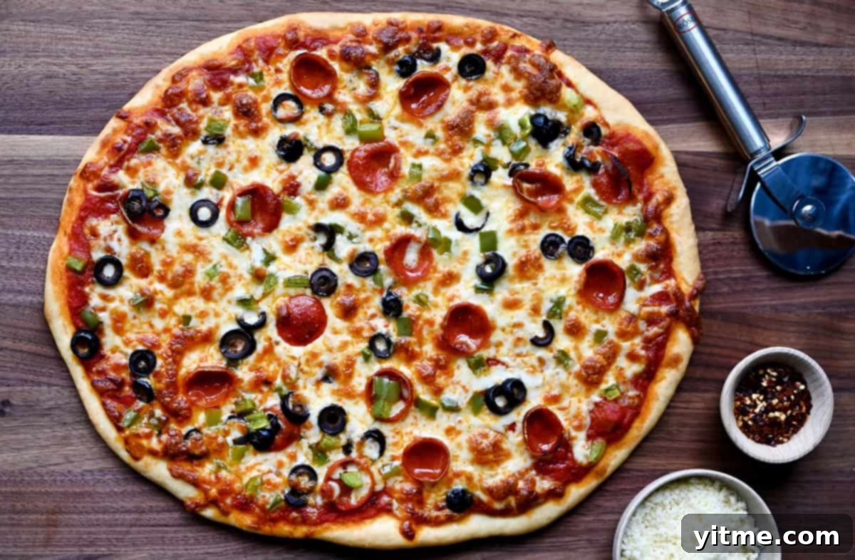 Freshly baked pizza featuring a no-yeast crust, vibrant pizza sauce, perfectly melted cheese, an array of mini pepperoni, diced green pepper, and sliced black olives.