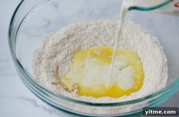 Effortless Cinnamon Swirls: A No-Yeast Recipe 3 A glass bowl with milk and butter being poured in