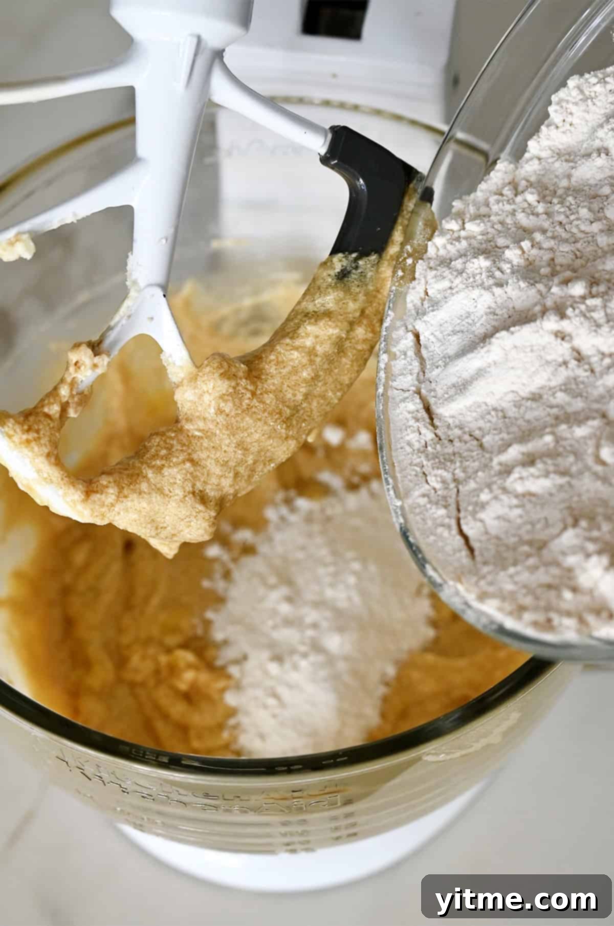 Slowly adding flour to banana cookie dough.