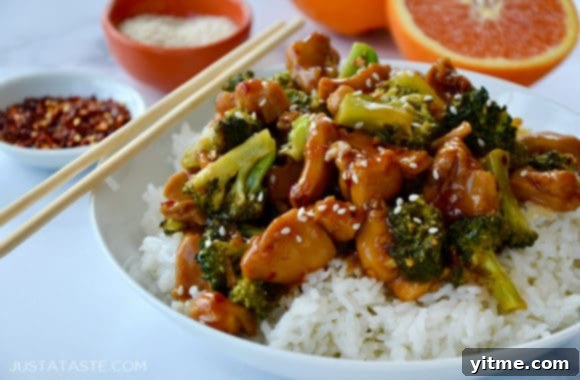 A bowl of the delectable Quick Orange Chicken and Broccoli, perfectly served over white rice and enjoyed with chopsticks