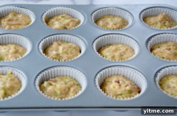 Muffin tin lined with paper filled with batter