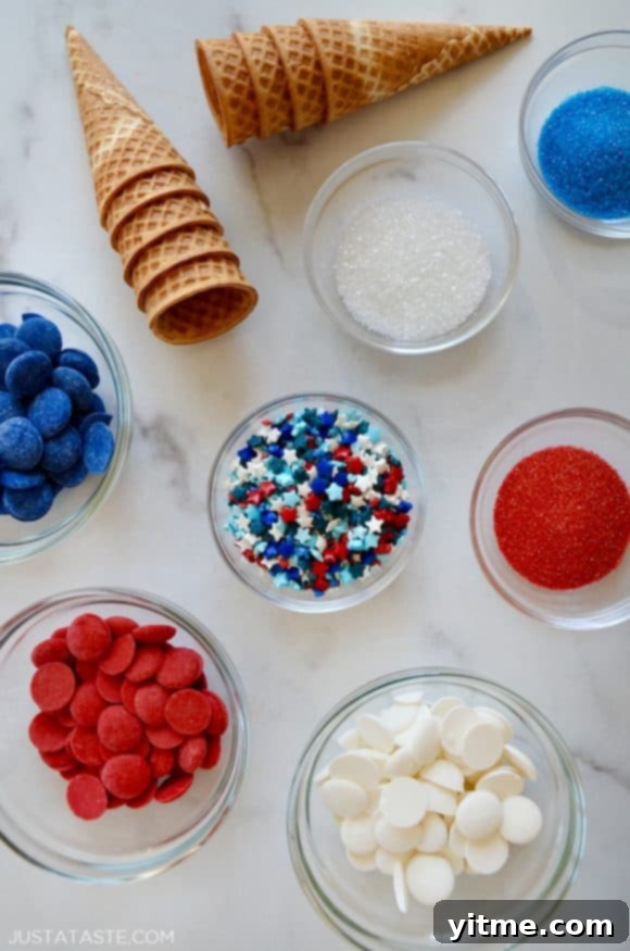 Various sized bowls with red, white, and blue sprinkles and candy melts next to waffle cones