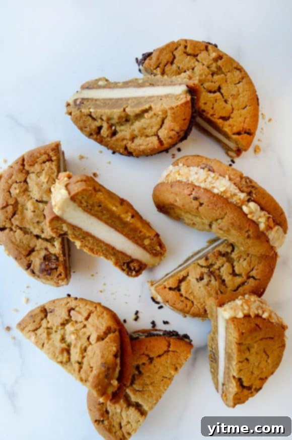 A top-down view of halved ice cream sandwiches on a white marble background