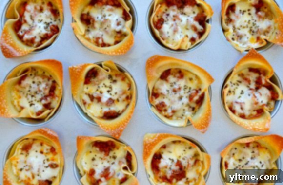 Easy Muffin Tin Lasagna Cups garnished with fresh Italian seasoning on a white serving plate