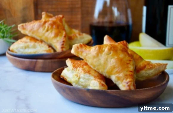 Delicious fruit and cheese turnovers served on wooden plates with wine glasses
