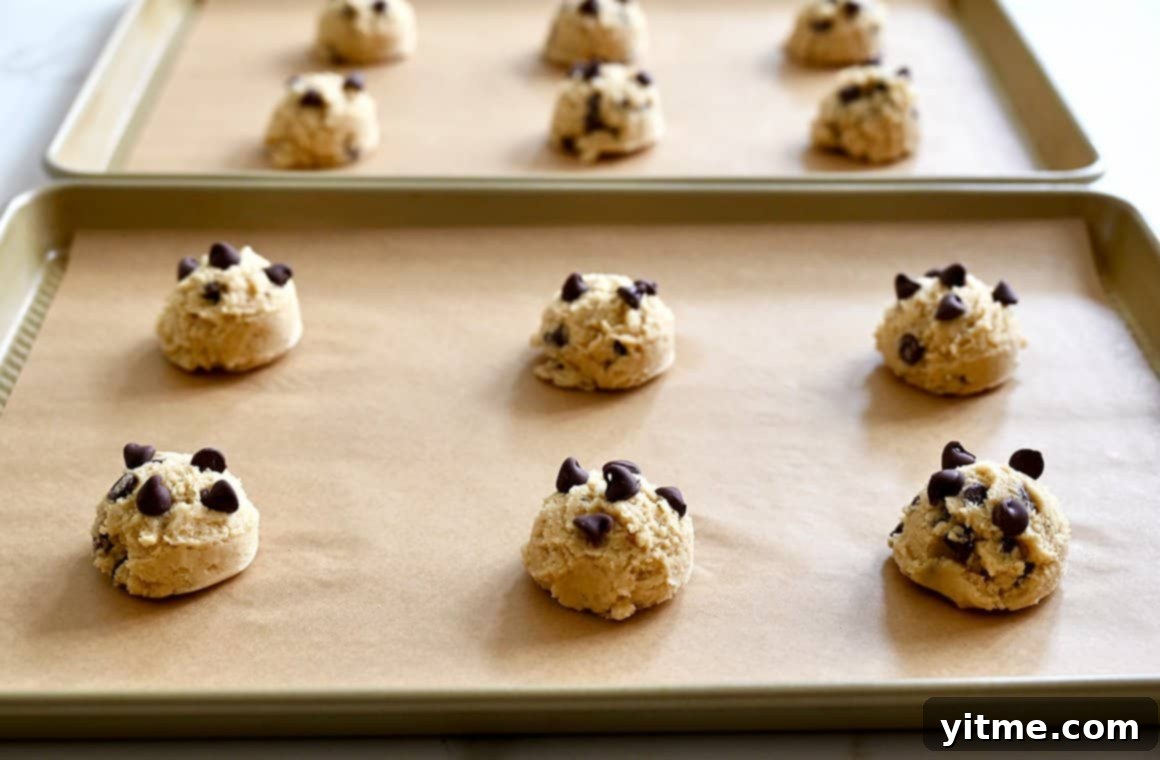 Cookie dough scoops on parchment-lined baking sheets