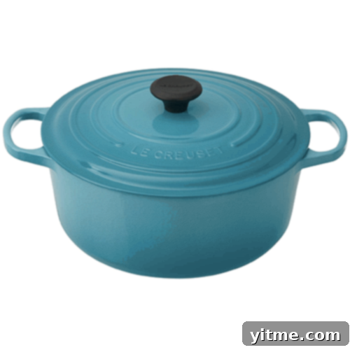 Flavorcast 5 A classic, vibrant orange Le Creuset Dutch Oven, a symbol of quality and durability in the kitchen, perfect for slow cooking, braising, and baking with superior heat retention.