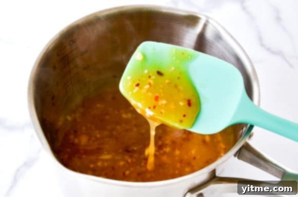 Spatula stirring the luscious honey-garlic glaze in a pan