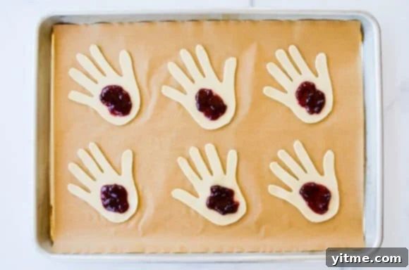 Pie dough filled with jam on a baking sheet