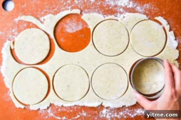 Hand with circle cookie cutter cutting pie dough
