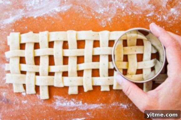 Hand holding circle cookie cutter over lattice 