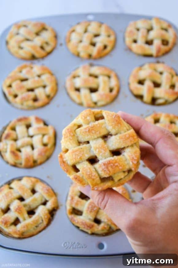 Hand holding easy muffin tin mini apple pie with lattice pie crust
