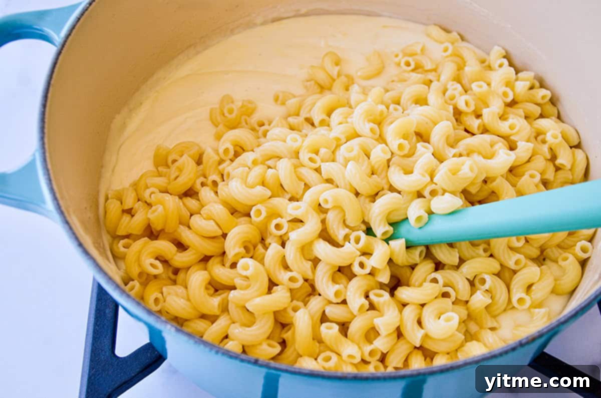Sharp & Speedy: 30-Minute White Cheddar Mac 4 Mixing Pasta into Cheese Sauce
