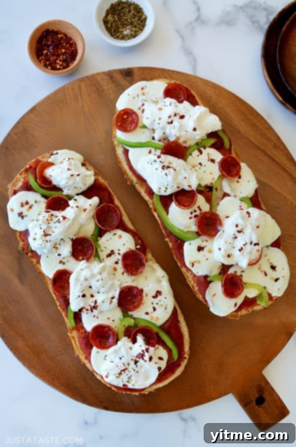 Delicious French Bread Pizza with Burrata on a wooden cutting board, ready to serve.