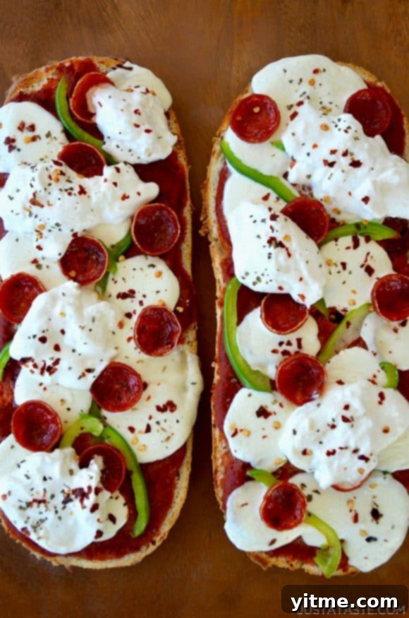 Overhead shot of French bread pizza topped with creamy burrata cheese and a sprinkle of crushed red pepper flakes for added flavor and heat.
