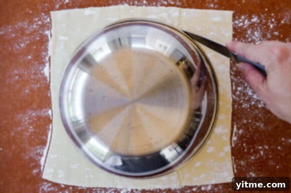 Effortless Snowflake Pastry Delight 4 A small bowl placed on top of a sheet of puff pastry, used as a guide for cutting the circular shape.