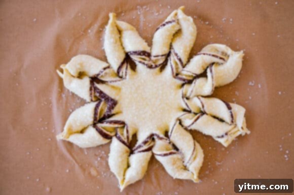 Effortless Snowflake Pastry Delight 8 A close-up of the completed puff pastry snowflake before baking, showcasing the twisted sections and overall shape.
