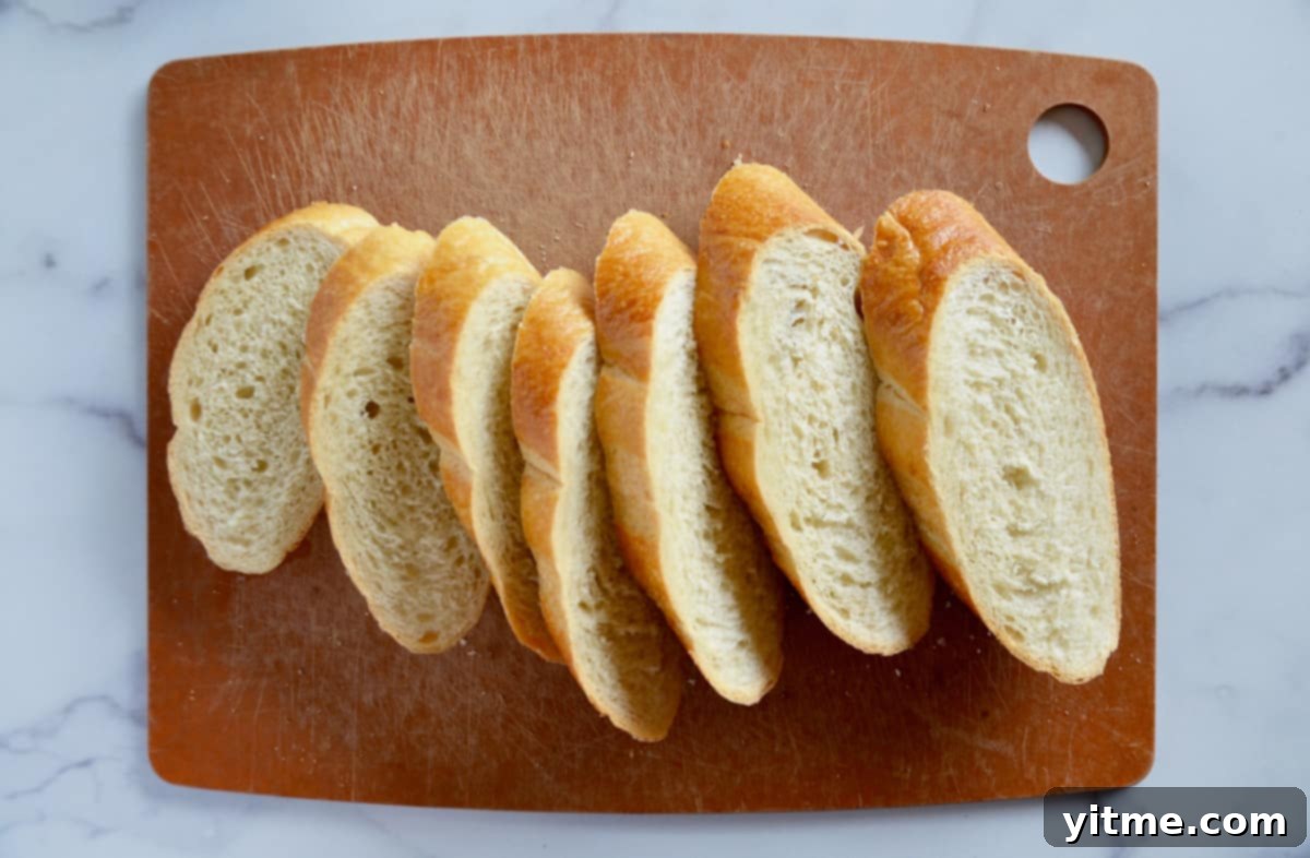 Thick slices of bread on a cutting board, ready for soaking.
