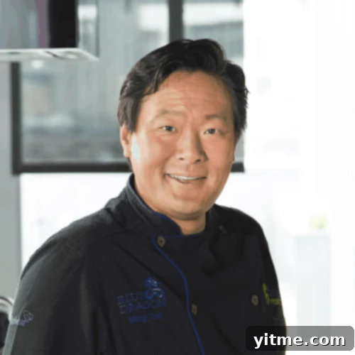 Portrait of Chef Ming Tsai smiling, wearing a blue chef's coat.