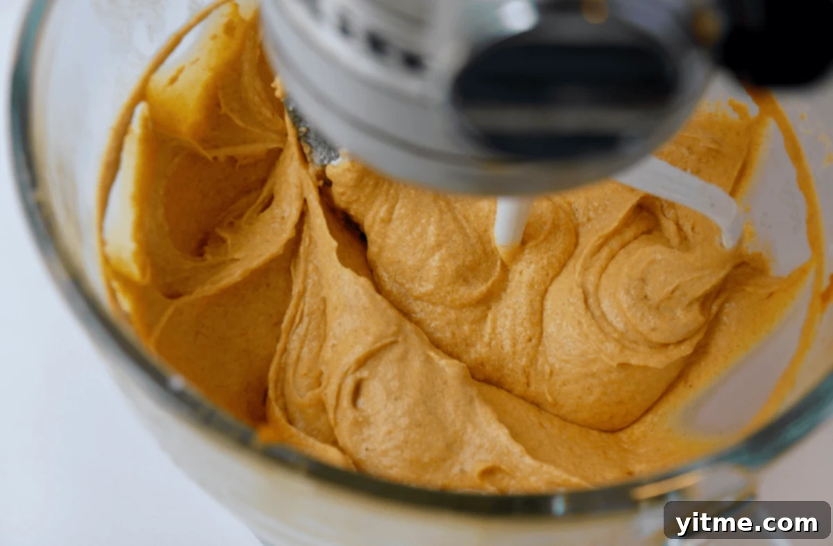 Ultimate Autumn Pumpkin Bread 3 Pumpkin bread batter being mixed in a stand mixer with a paddle attachment.