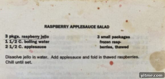An aged recipe card showcasing the handwritten recipe for the applesauce jello salad