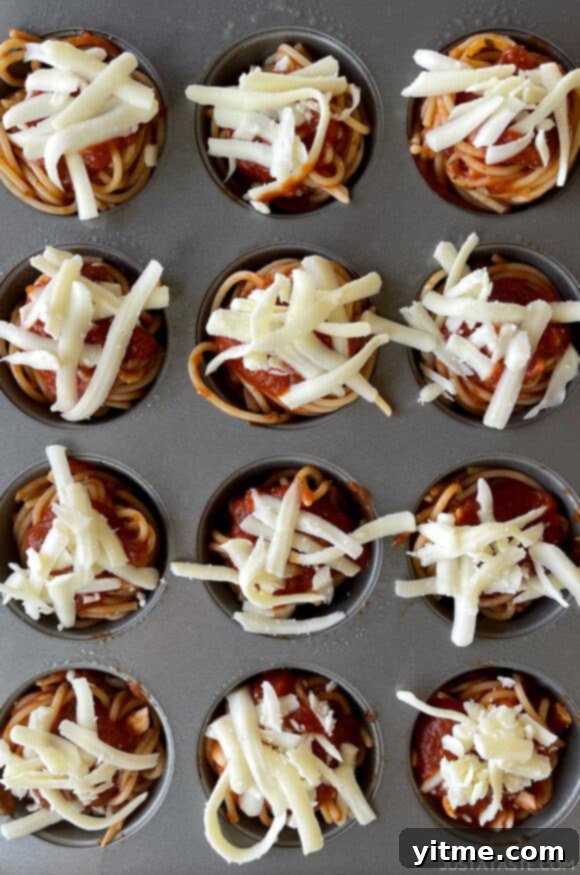 Cheesy Spaghetti Bites 3 A view of a muffin pan containing spaghetti cupcakes