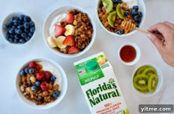 Orange-Kissed Honey Granola Parfaits 6 A top-down view of granola parfaits in bowls and a carton of orange juice