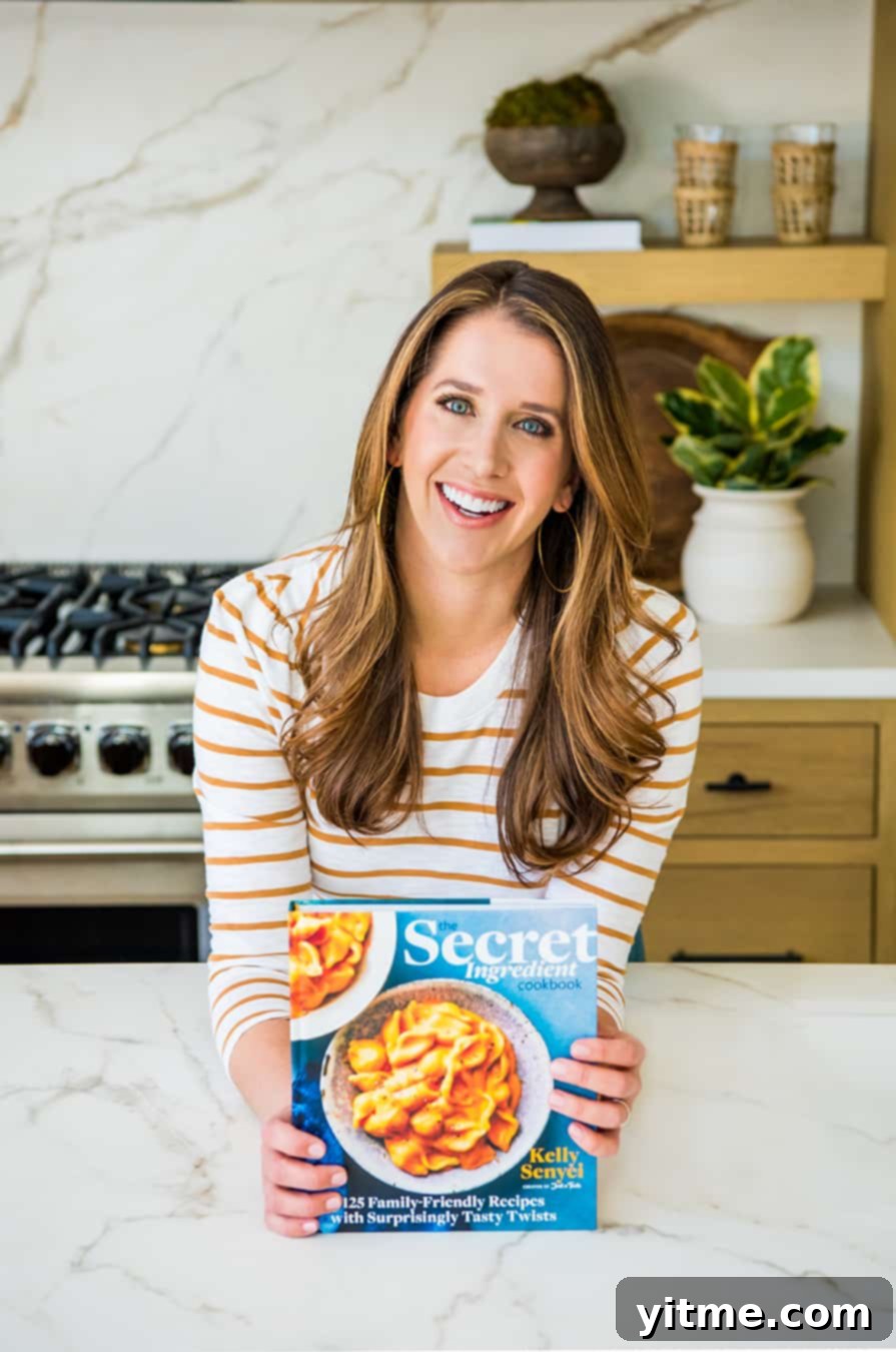 A Taste of Secrecy: Unveiling the Culinary Vault 2 Kelly Senyei holding a copy of The Secret Ingredient Cookbook