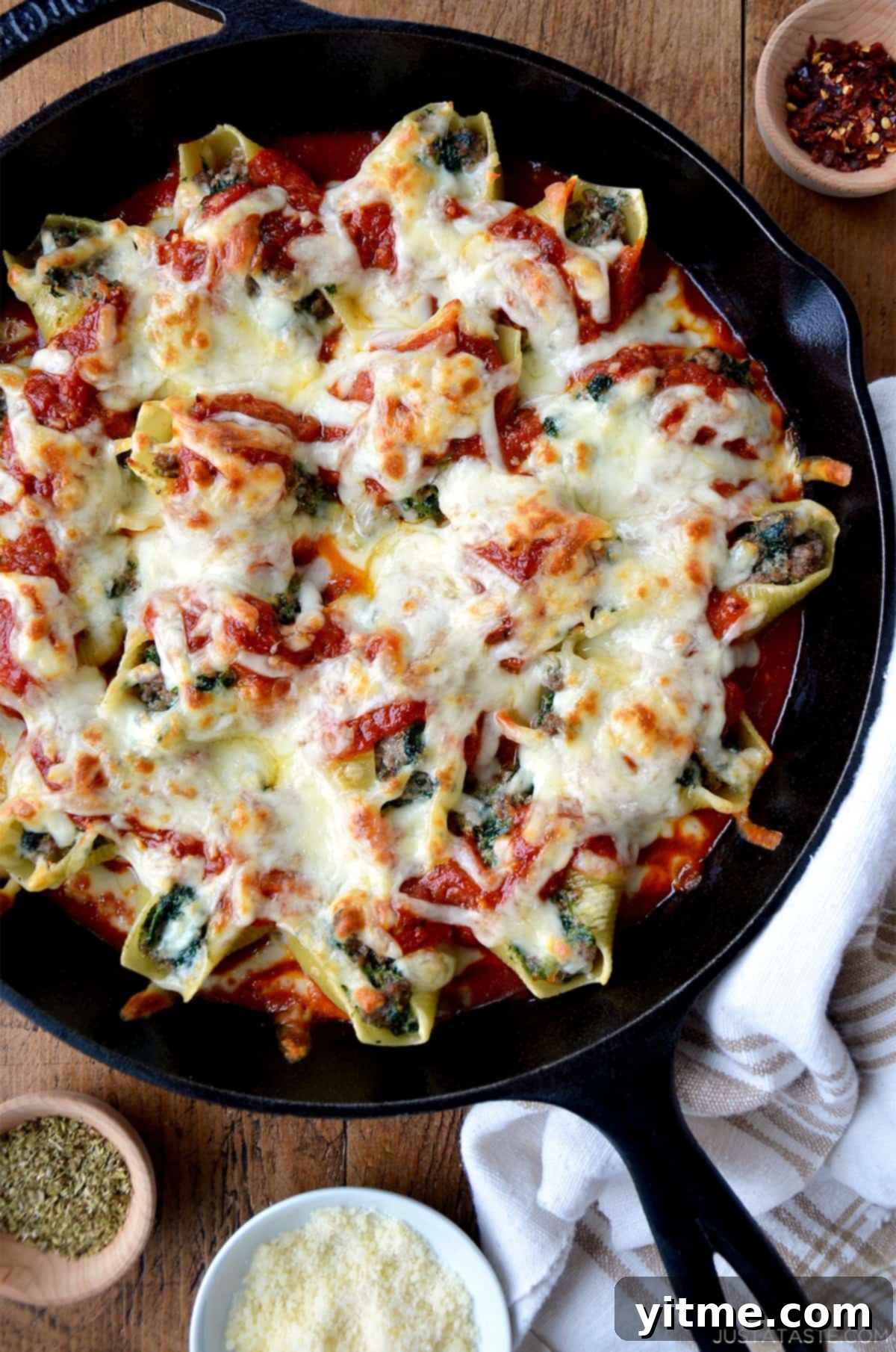 Stuffed shells with meat, cheese and spinach in a skillet with marinara sauce.