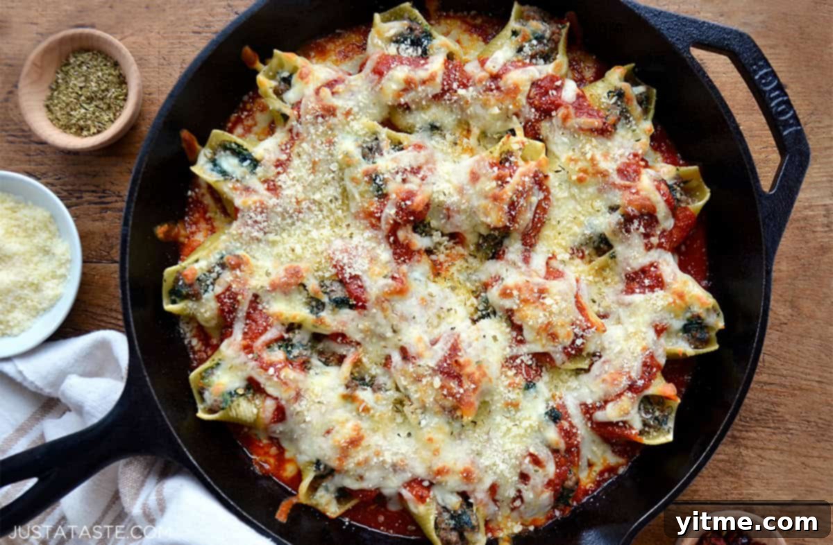 A cast-iron skillet containing stuffed shells with meat and ricotta.