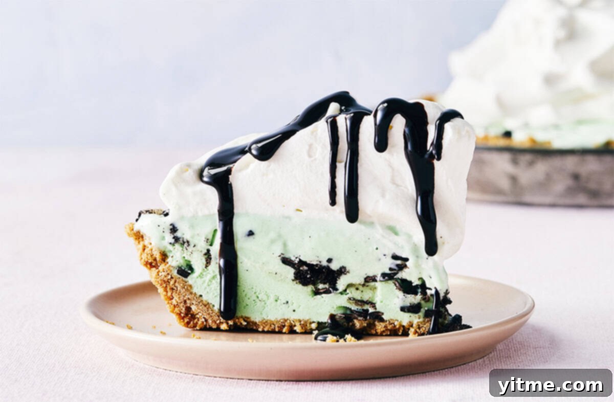 Mystery Ingredient Ice Cream Pie 9 Mint chocolate chunk ice cream pie with whipped cream being drizzled with chocolate syrup, showcasing a perfect slice.
