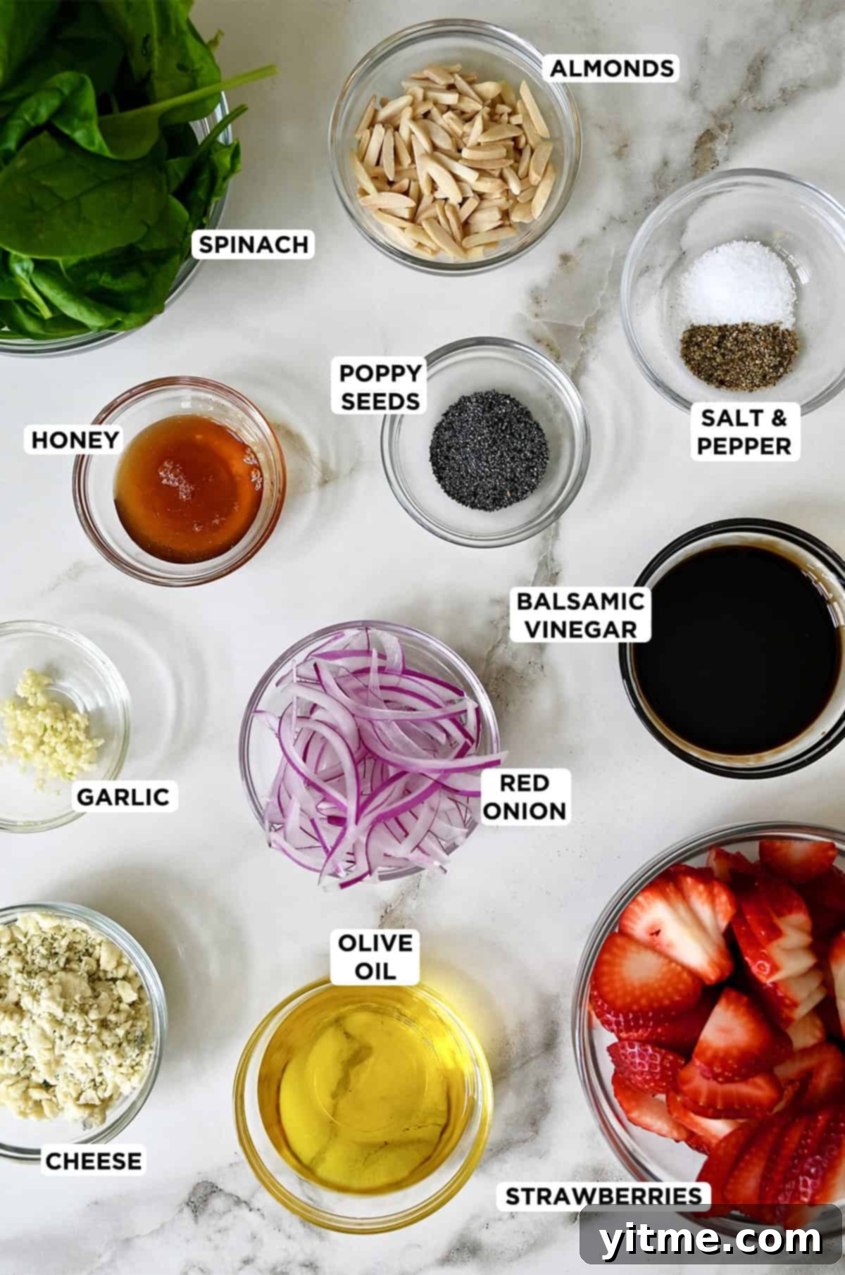 Strawberry spinach salad ingredients in glass bowls