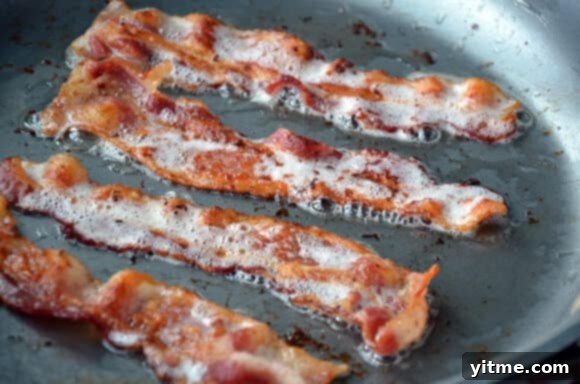 Beef and vegetables cooking slowly for hash Crock Pot Beef and Bacon Hash simmering in slow cooker