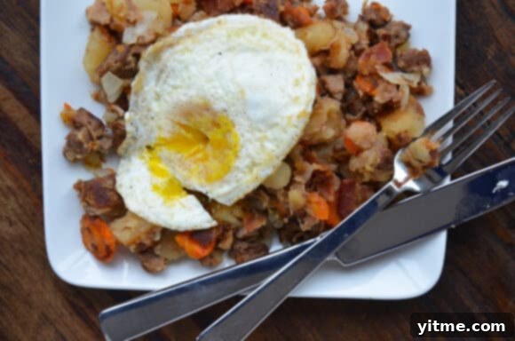 Delicious Crock Pot Beef and Bacon Hash topped with an egg Serving suggestion for Crock Pot Beef and Bacon Hash with fried egg