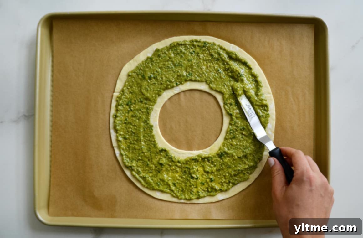 Spreading pesto evenly on puff pastry with a spatula
