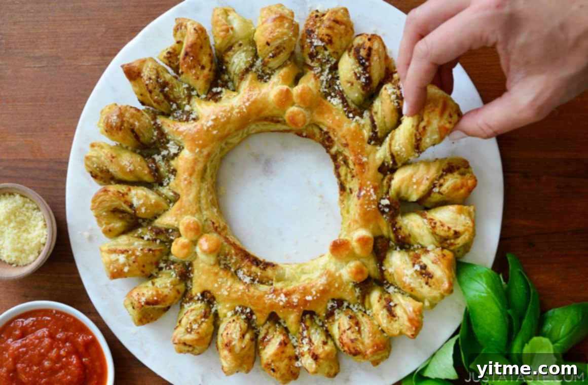 Reaching for a piece of Pesto Puff Pastry Wreath