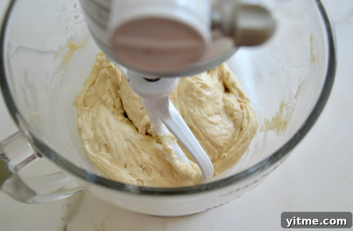 Sour Cream Doughnut Bites 4 A large glass stand mixer bowl containing the muffin batter, showcasing the smooth and creamy texture achieved with sour cream.