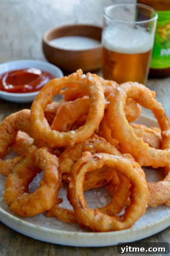 Top Recipes That Defined 2021 7 A plate of fried onion rings with beer and ketchup in the background