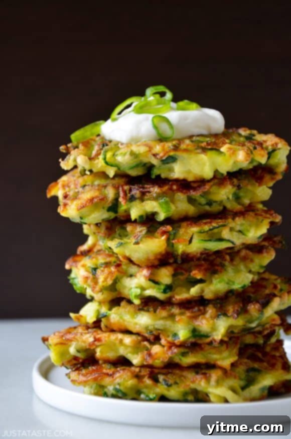 Top Recipes That Defined 2021 10 Tall stack of 5-ingredient zucchini fritters topped with sour cream and scallions