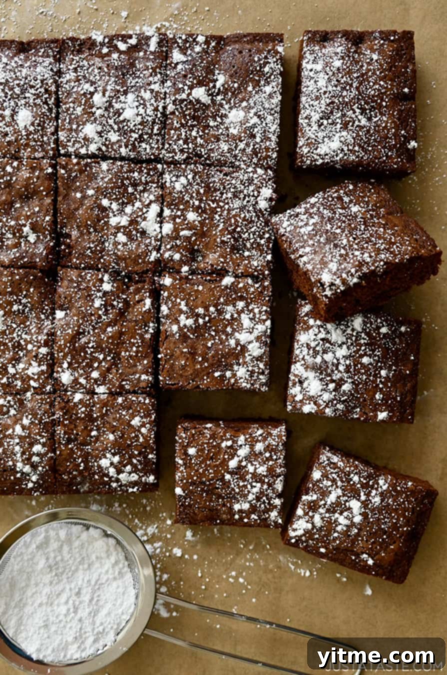 Cleanly cut brownies dusted with powdered sugar, showcasing perfect, straight edges.