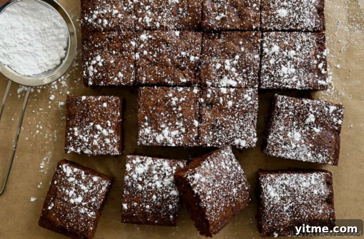 Perfectly cut brownie squares, evenly dusted with powdered sugar, arranged neatly.