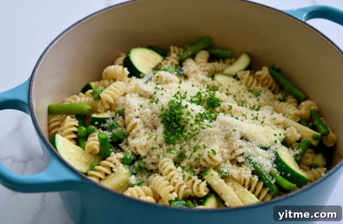 Pasta Primavera with zucchini, asparagus, and peas, sprinkled with Parmesan and chives.